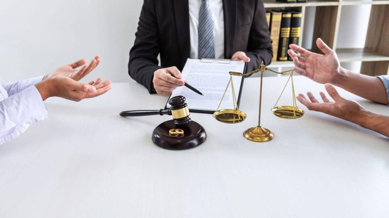 a group of people sitting around a table with a scale of justice